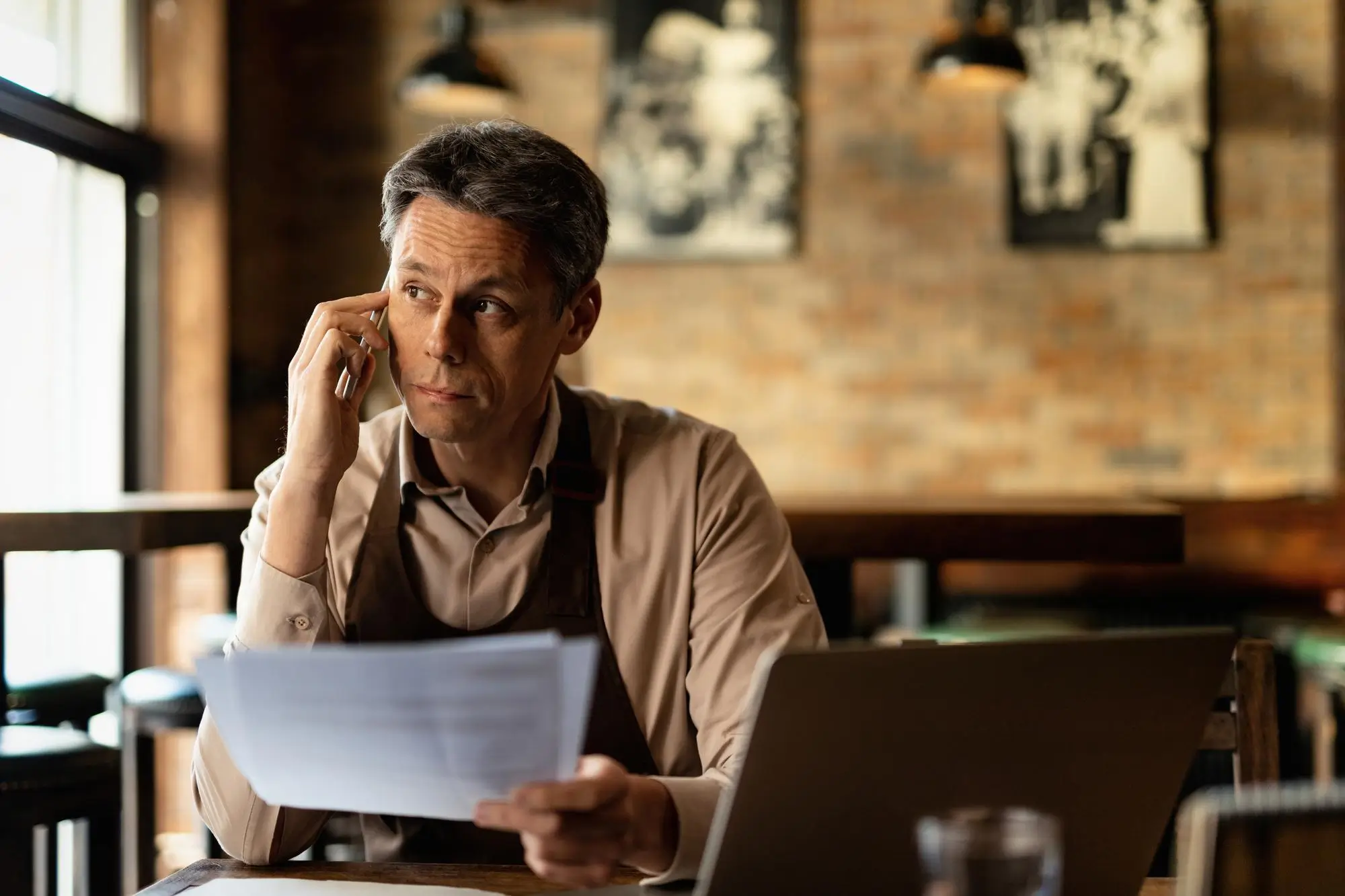 Mid adult bar owner analyzing documents